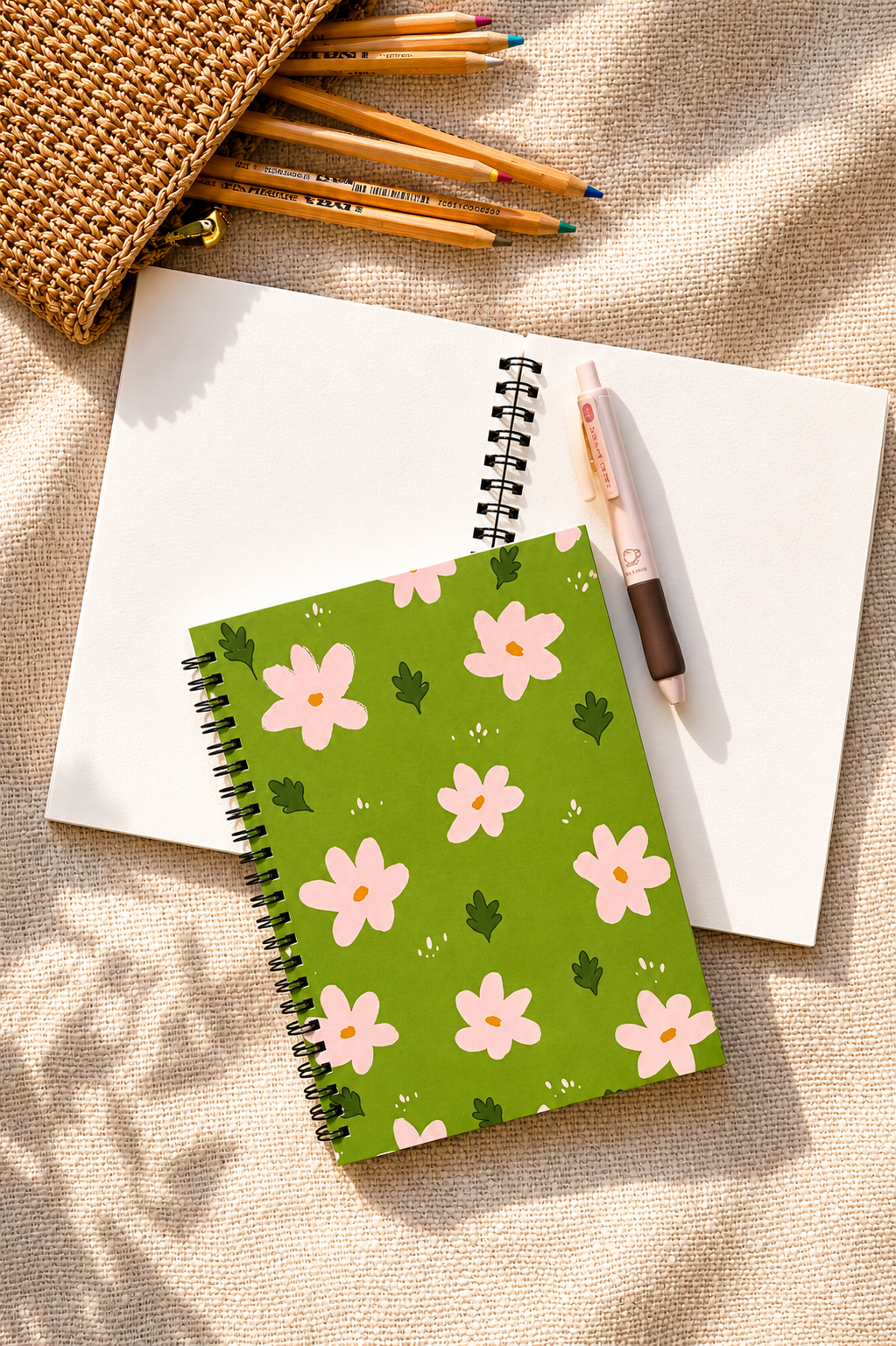 Floral notebook on a textured surface with pencils